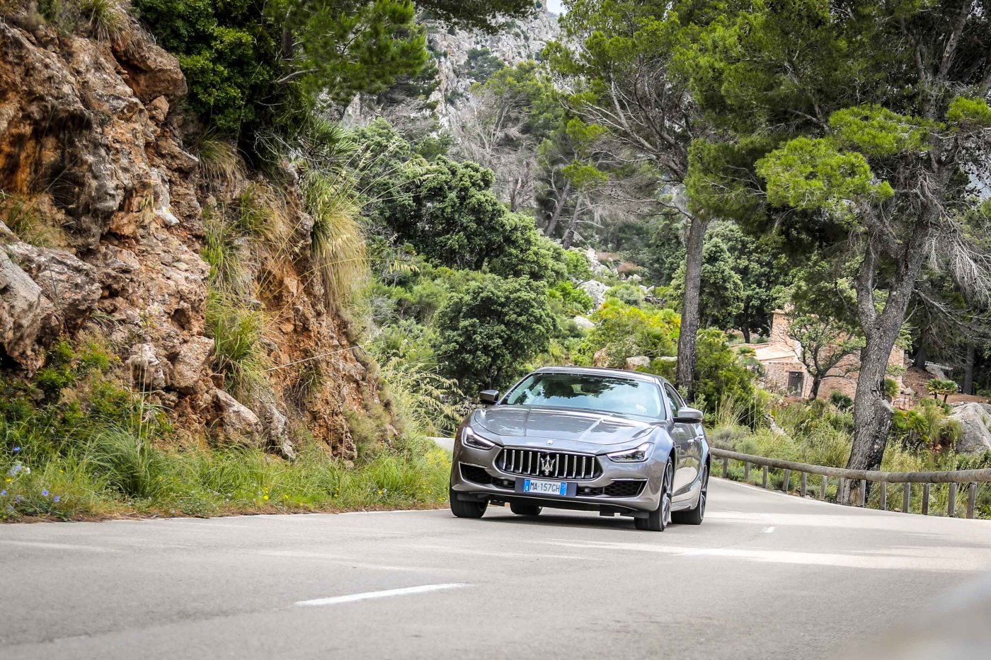 Maserati Ghibli riding on road with trees