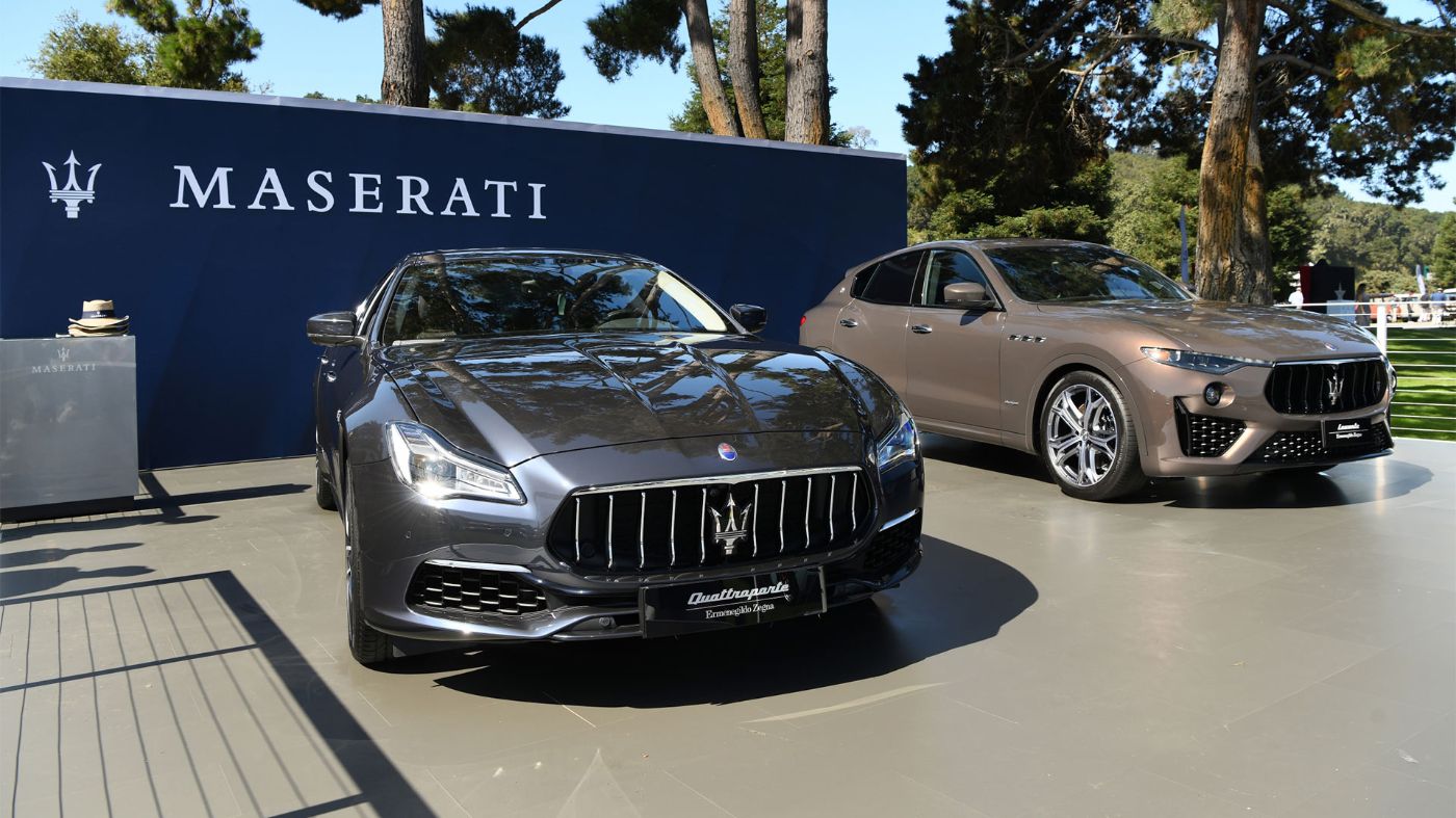 Maserati Quattroporte and Levante in front of Blue Maserati Banner
